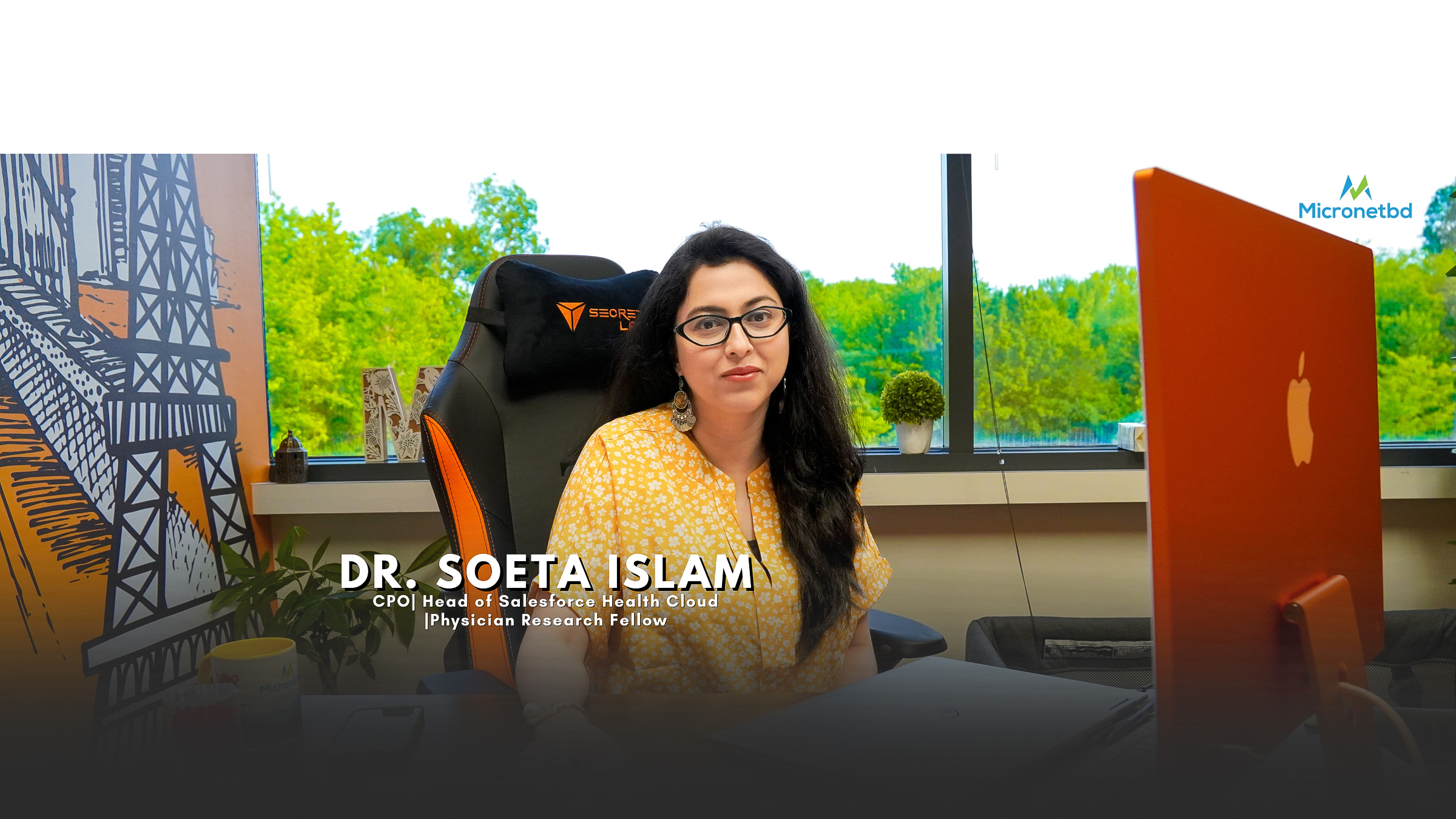 Professional woman with glasses, wearing a yellow patterned blouse, sitting in an office with a scenic view. Beside her is a desk with various items and an orange laptop. A graphic on the left depicts industrial structures, and on the right, there's a logo for 'Micronetbd'. Text overlay identifies her as 'DR. SOETA ISLAM, CPO | Head of Salesforce Health Cloud | Physician Research Fellow